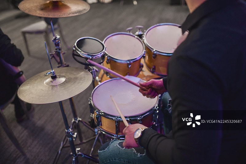 鼓手在现场音乐演奏会上演奏鼓组和镲片图片素材