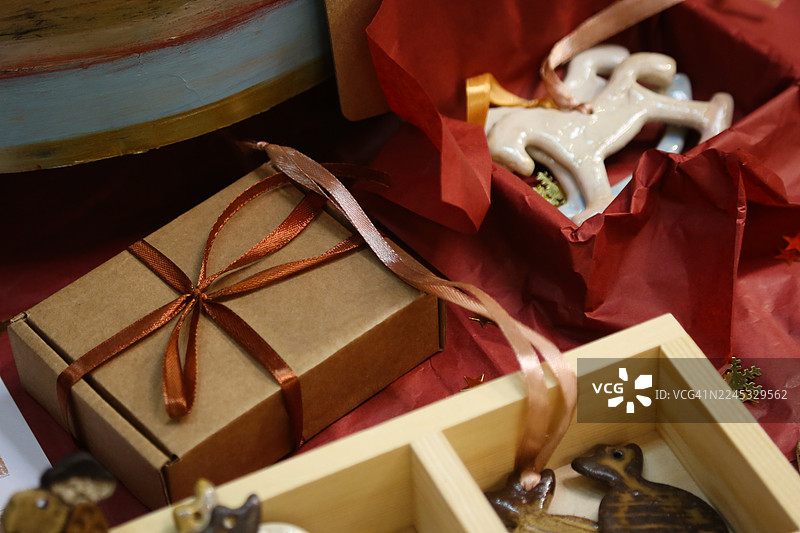 本地圣诞集市上的棕色牛皮纸礼品盒和手工陶瓷圣诞玩具图片素材