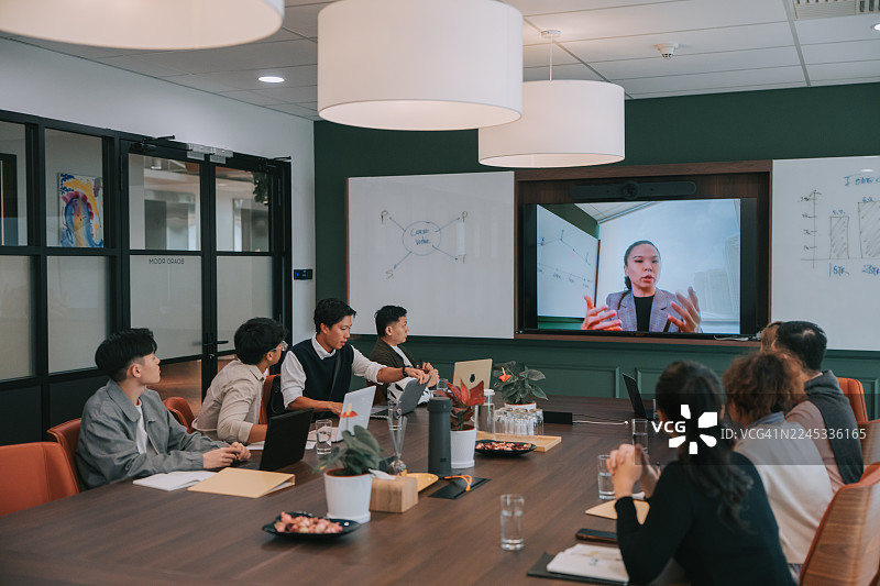 亚洲多元种族商务团队举行混合会议，女性同事通过视频通话进行演示图片素材