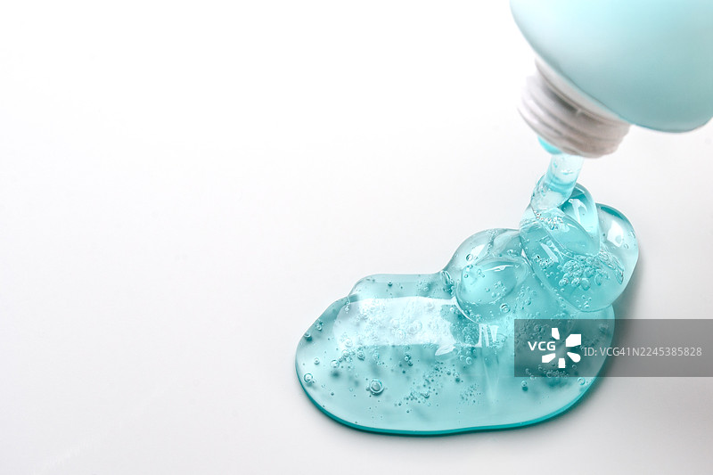 浅蓝色凝胶从瓶中挤出到光滑的表面上图片素材
