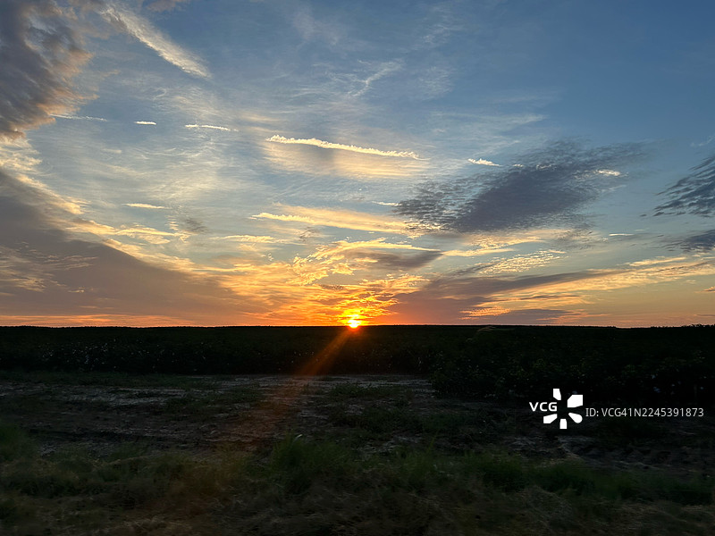 佐治亚州，深色田野上空，绚丽的日落与戏剧性的云彩交织，构成一幅宁静而风景如画的景象图片素材