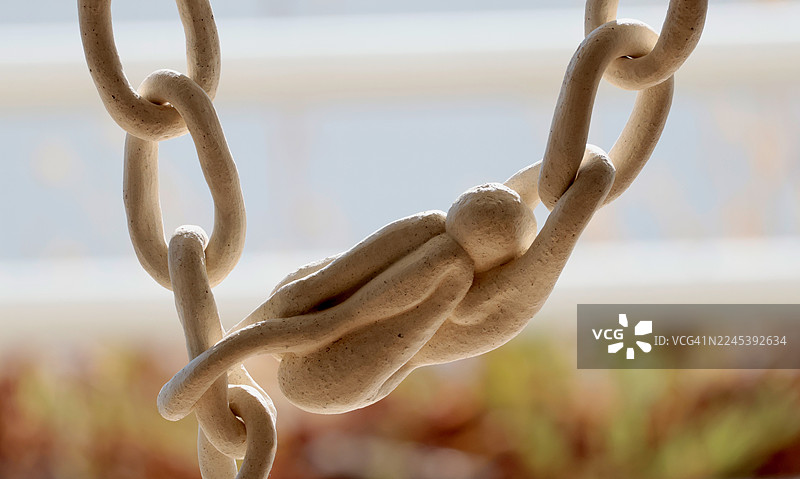 装饰性陶瓷链的特写，具有独特的绳结状链节，在自然光下照明。图片素材