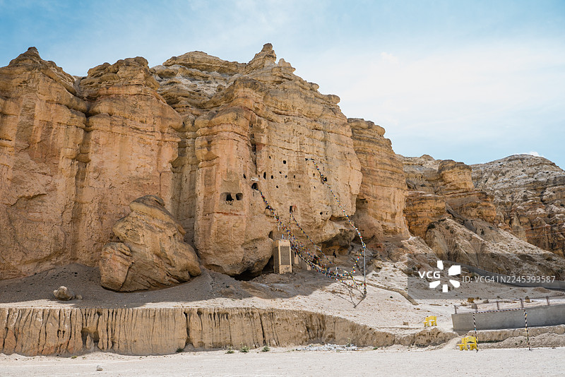 尼泊尔偏远地区，蓝天下古老的岩石构造，点缀着祈祷的经幡和洞穴居所图片素材