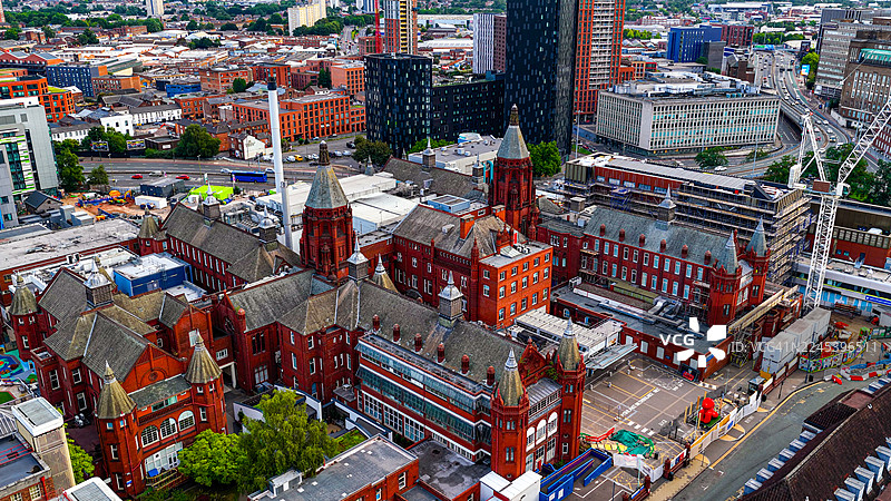伯明翰儿童医院的鸟瞰图，历史悠久的红砖建筑，维多利亚哥特式建筑风格，周围是现代城市开发和道路，医疗保健和遗产概念在西米德兰兹图片素材