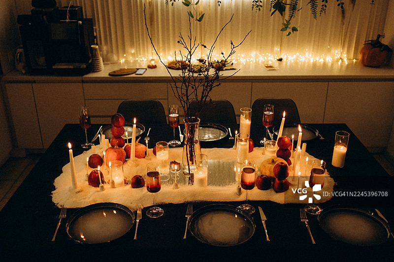 万圣节晚餐餐桌布置，有点亮的蜡烛和秋季装饰图片素材
