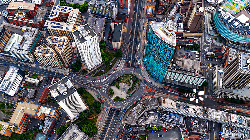 伯明翰市中心霍洛威马戏团（Holloway Circus）及其宝塔环形交叉路（Pagoda roundabout）的鸟瞰图，周围环绕着住宅高层塔楼和商业建筑，展现了西米德兰兹的城市天际线和交通枢纽概念图片素材
