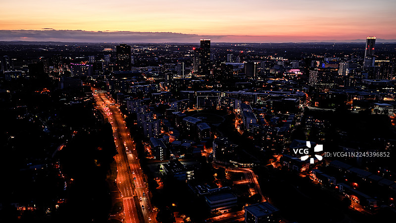 伯明翰市中心夜景航拍，展示了华灯初上的摩天大楼、繁忙的街道和城市天际线，体现了西米德兰兹的现代建筑和商业区的概念。图片素材