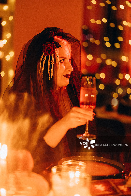 戴着哥特式面纱和骷髅配饰的女人在庆祝万圣节图片素材