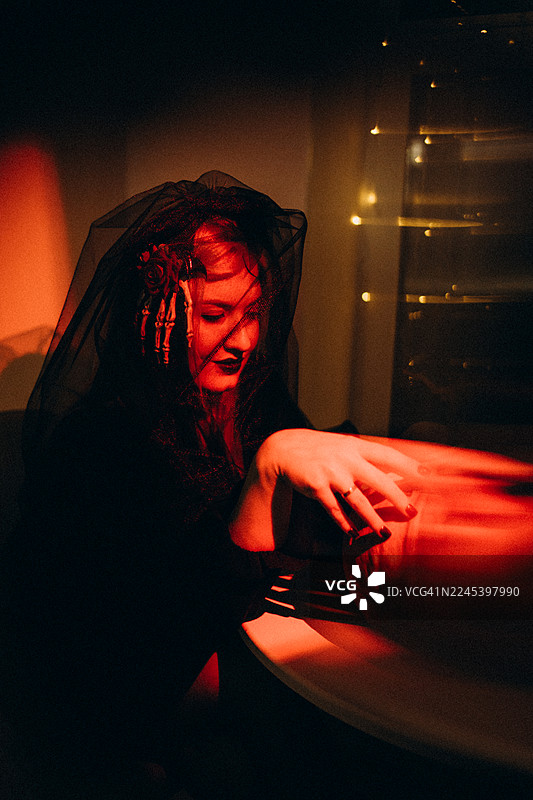 万圣夜，身穿女巫服装的女子触摸南瓜图片素材