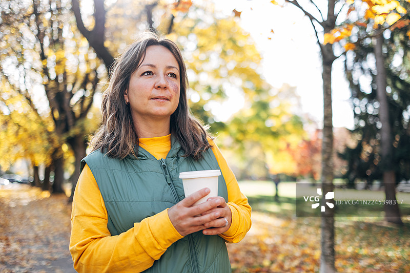 秋日公园里，一位女士在喝咖啡，静思自然图片素材