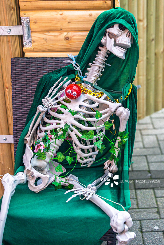 身着绿色斗篷的骷髅，为万圣节在德里装饰图片素材
