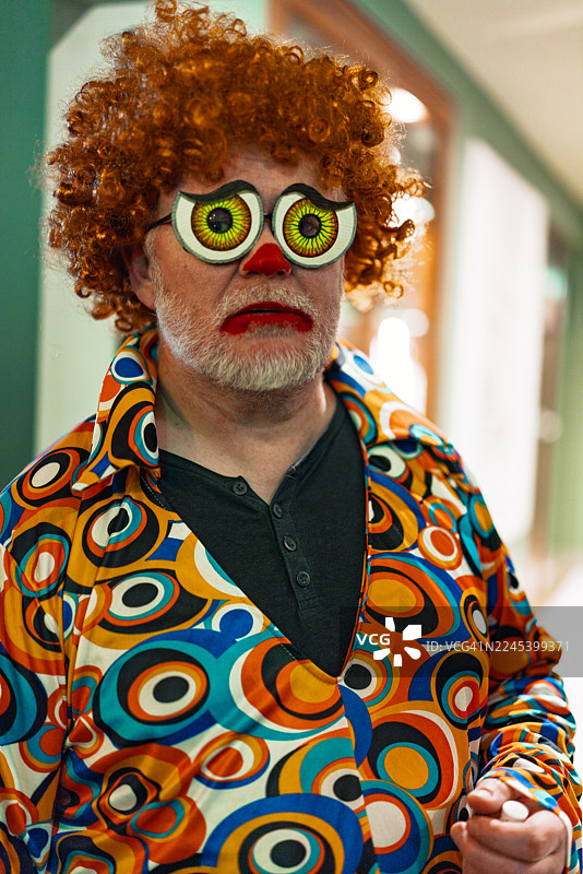 万圣节装扮成小丑并戴着螺旋眼镜的男人图片素材