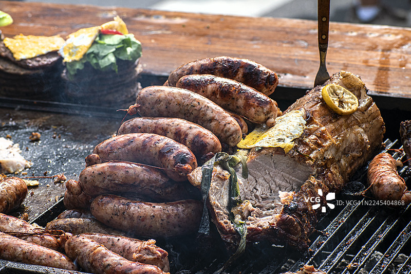 烤架上烤制的香肠、肉类和汉堡。烧烤。阿萨多。阿根廷传统美食。图片素材