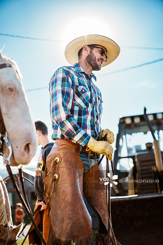 阳光明媚的一天，牛仔正在与他的马匹一同劳作图片素材