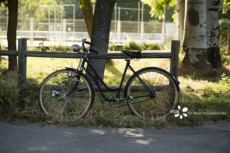 公园里靠在木栅栏上的复古自行车图片素材