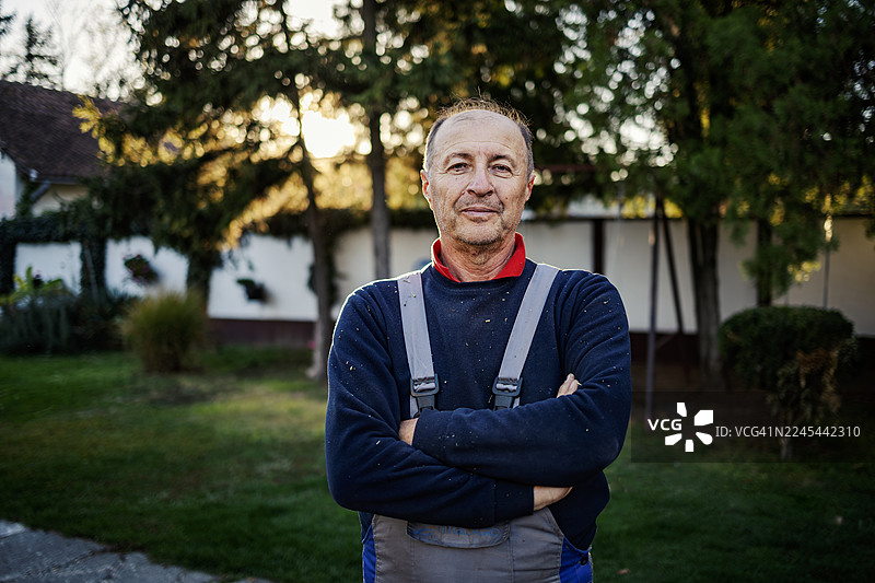 穿着工装的成熟男子在户外站着图片素材