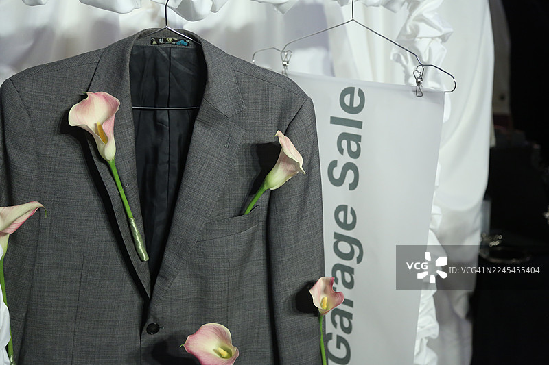 车库甩卖招牌，搭配时尚灰色智能休闲西装夹克，并用粉彩粉色马蹄莲花装饰图片素材