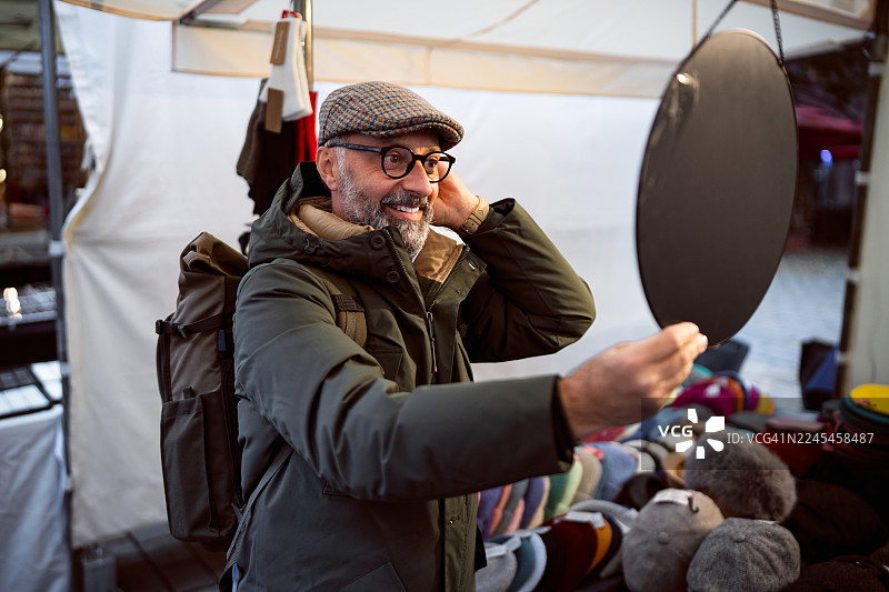 中年男子在柏林Hackescher Markt照镜子给自己试戴帽子图片素材