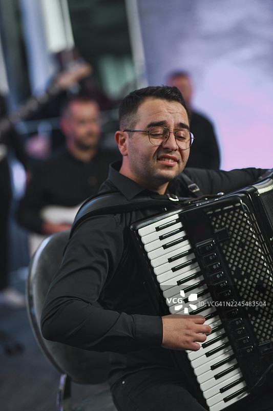 乐队现场演奏，手风琴手充满活力地专注于表演图片素材