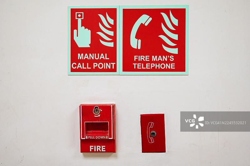 墙上的消防安全手册、火警报警按钮和消防员电话图片素材