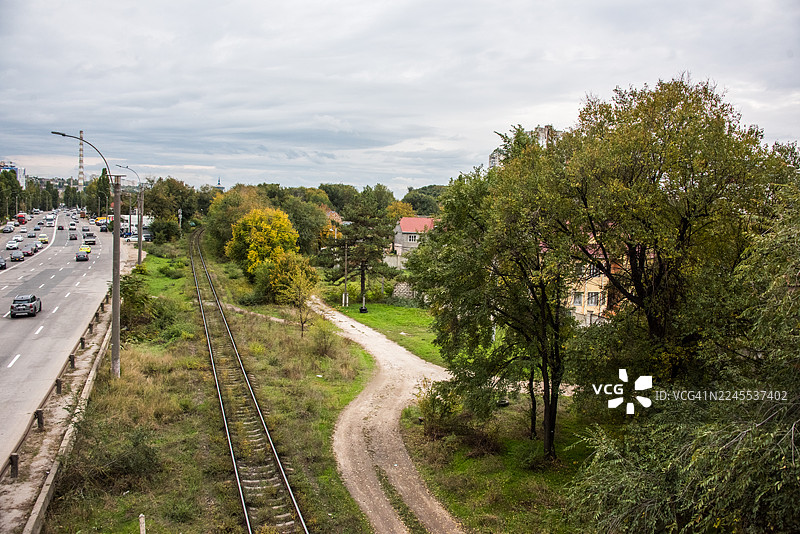 弯曲的工业铁路线与车行道并列图片素材