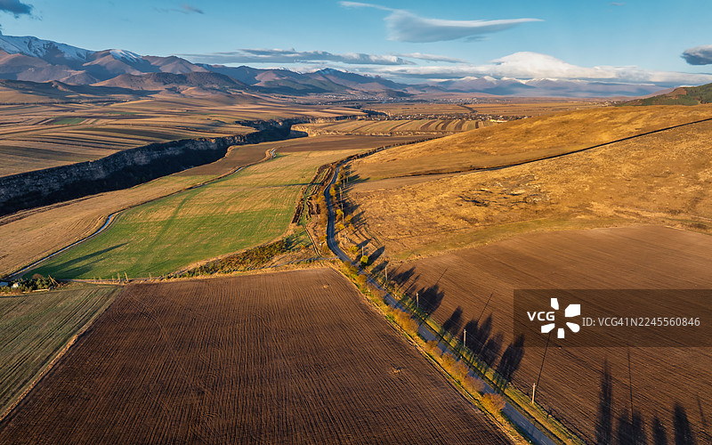 亚美尼亚洛里省农田和村庄的鸟瞰图——日出后光线下带有山脉背景的几何农田。图片素材