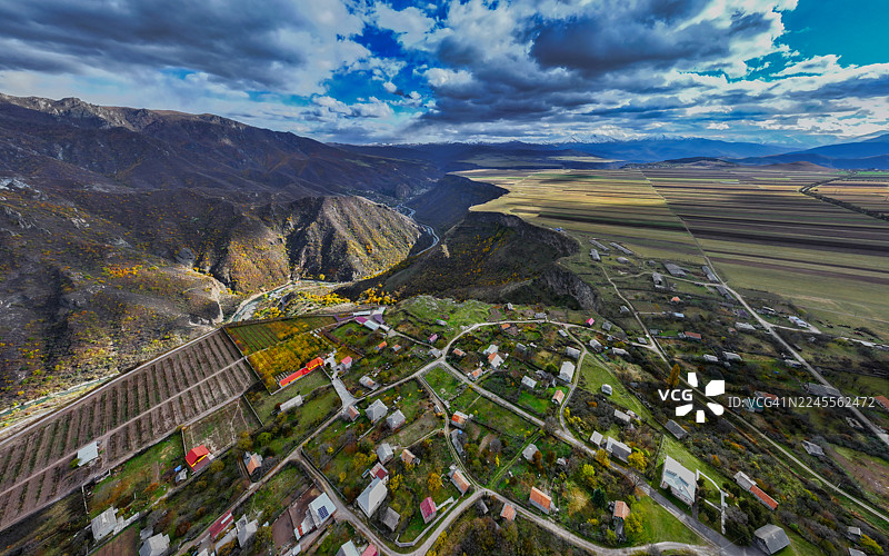 从空中俯瞰亚美尼亚洛里省附近的农田和山脊，光影和云影投射其上，呈现出戏剧性的光影效果。图片素材