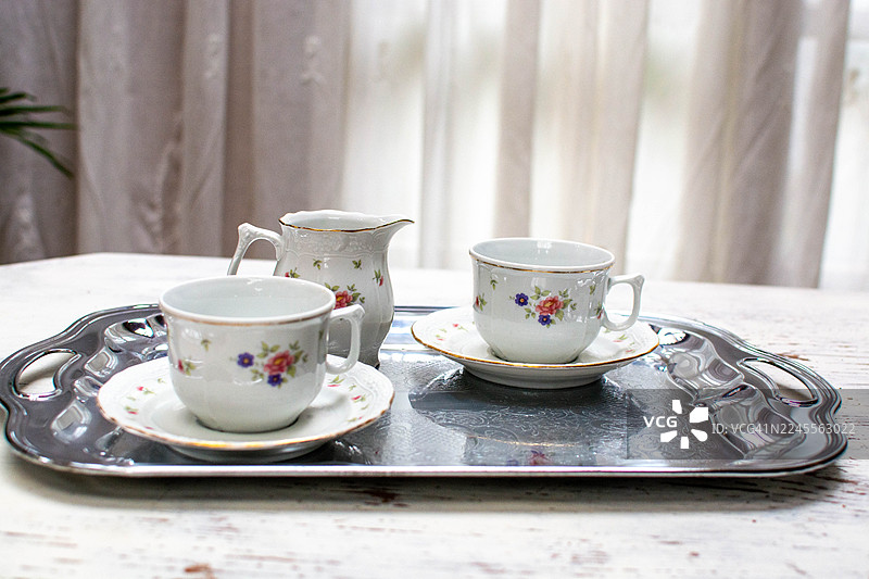 银盘上带有花卉图案的复古瓷茶具图片素材