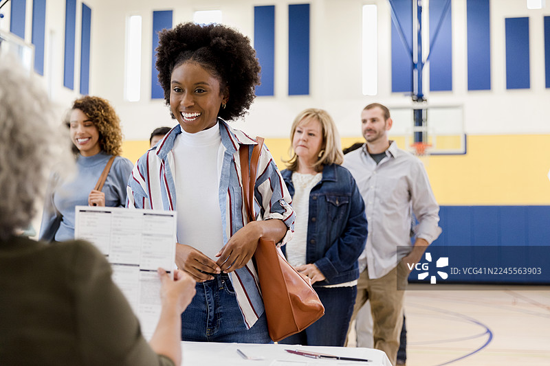 不同种族的人们在室内开心地排队等候图片素材
