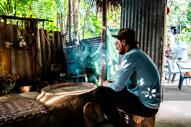 哥伦比亚瓜伊尼亚省原住民村落，一位成熟的男子正在乡村环境中寻找传统的烹饪空间。图片素材