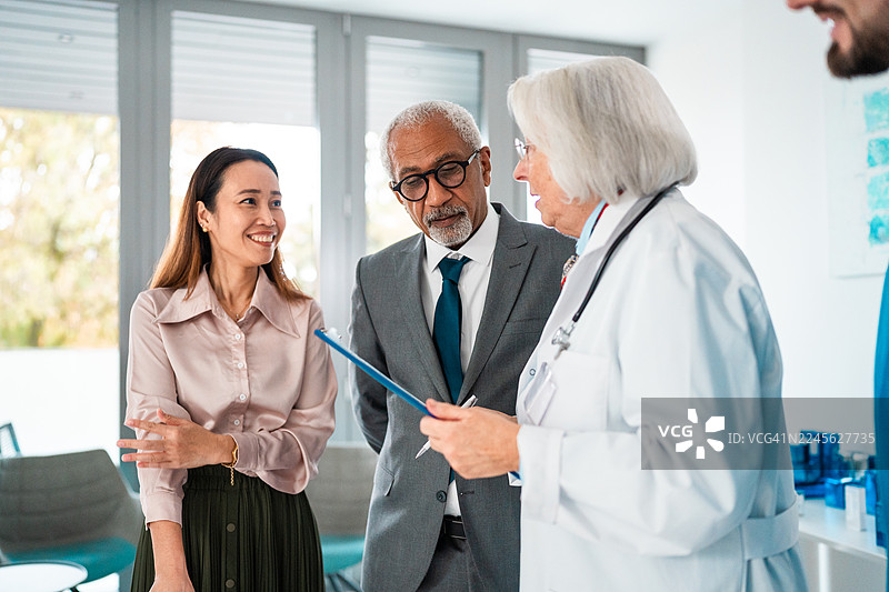 不同背景的医院员工和医生在候诊室进行协作互动图片素材