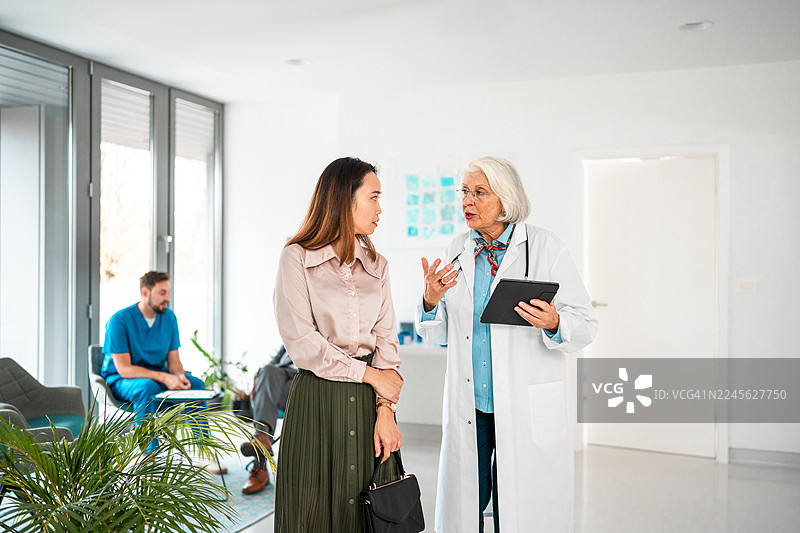 一位白人医生在办公室与一位多族裔经理讨论医院开销图片素材
