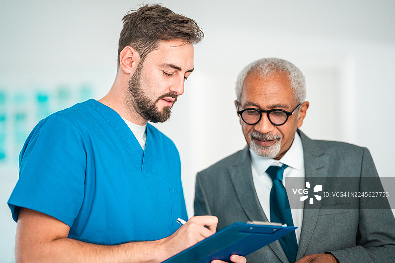 中年白人男性护士与多族裔经理讨论医院财务图片素材