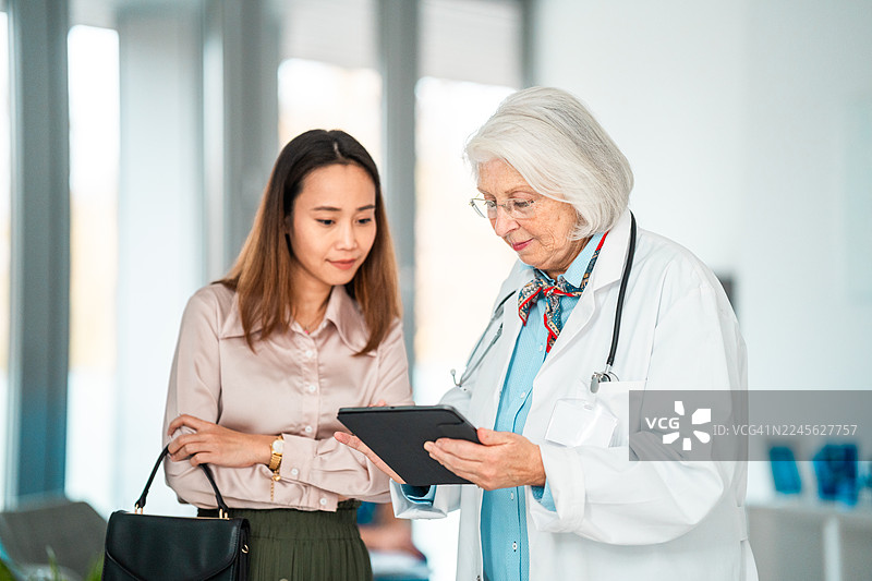 白人女医生和多元化女经理一起审查医院财务图片素材
