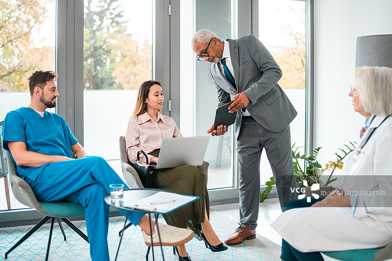 多元化的医院经理在现代办公室环境中与团队互动图片素材