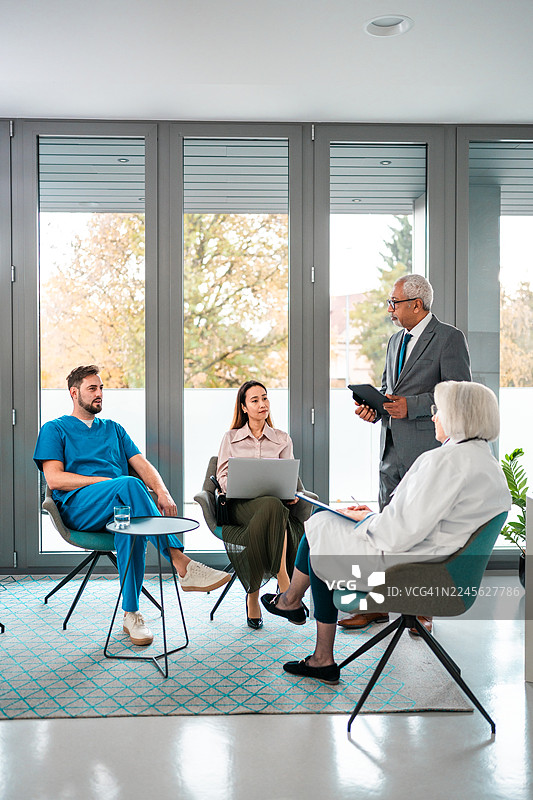 多元化的男性医院经理在现代办公室领导工作流程讨论图片素材