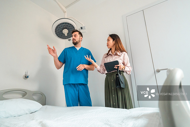 白人男性护士与多民族女性经理在病房讨论设备图片素材
