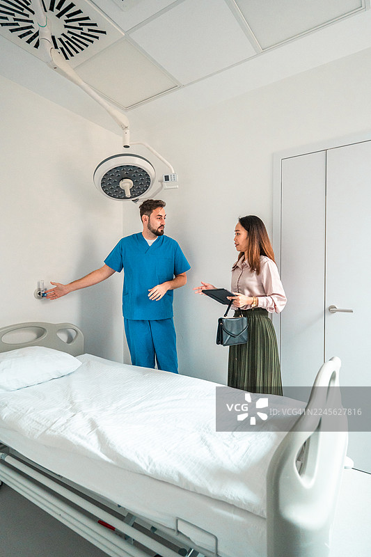白人男性护士与多民族女性医院经理评估医疗室图片素材