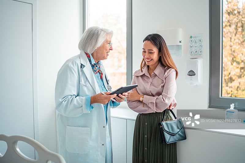 年长的白人女医生与中年医院经理合作评审设备图片素材