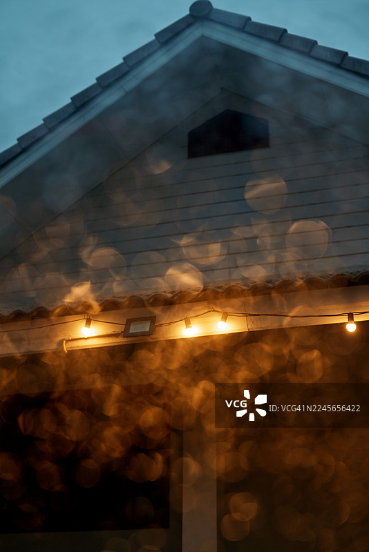 雨天窗户上的柔和散景灯光反射着屋顶图片素材