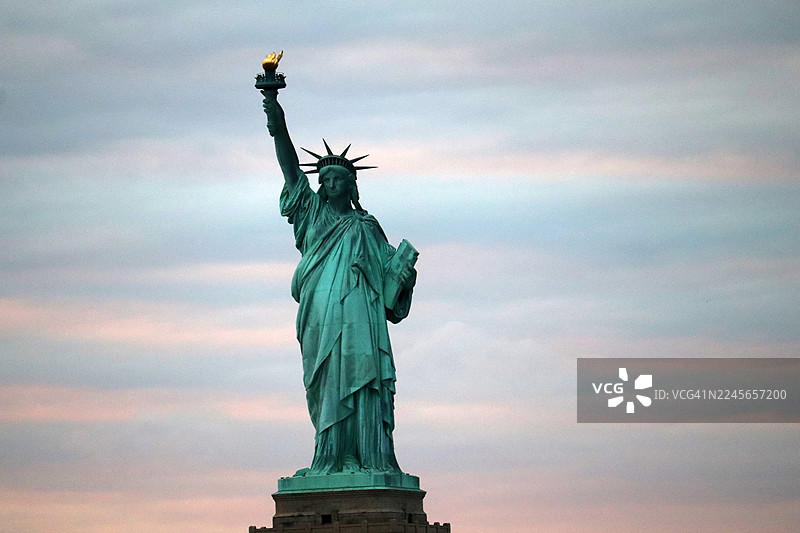 日落时自由女神像的壮丽景色/纽约市天际线/美国图片素材