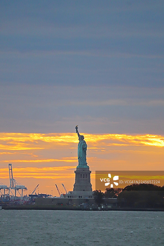 日落时自由女神像的壮丽景色/纽约市天际线/美国图片素材