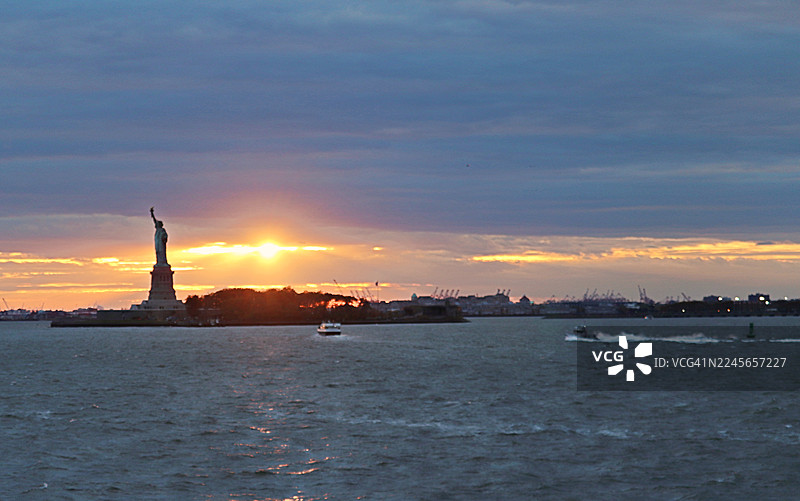 日落时分自由女神像的壮丽景色/纽约市天际线/美国图片素材