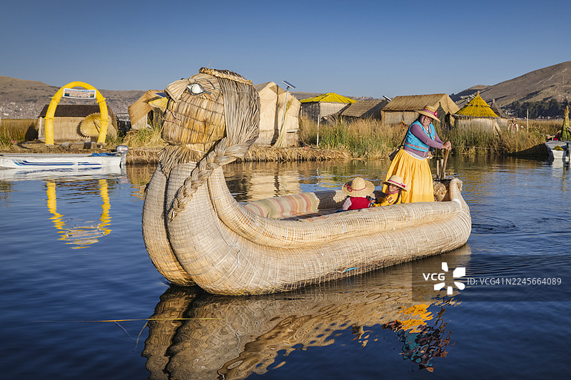 秘鲁年轻女子在的的喀喀湖乌鲁斯浮岛间航行图片素材