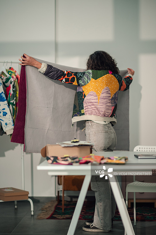 时装设计师在工作室拿着布料挑选颜色图片素材