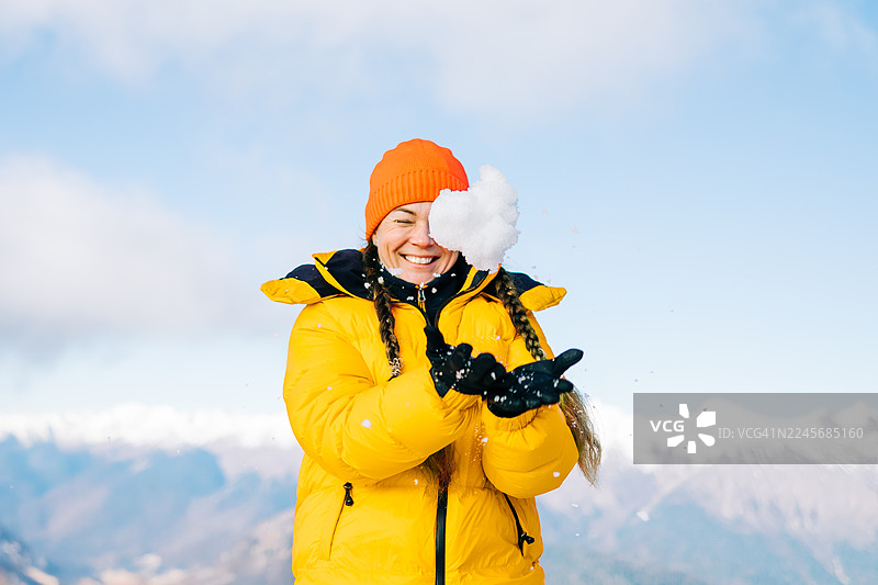 女人在寒冷的冬季山峦上玩雪图片素材