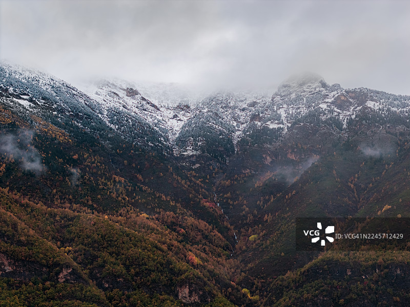 雪山与多彩秋林的航拍景观，构成一幅魔幻画卷。图片素材