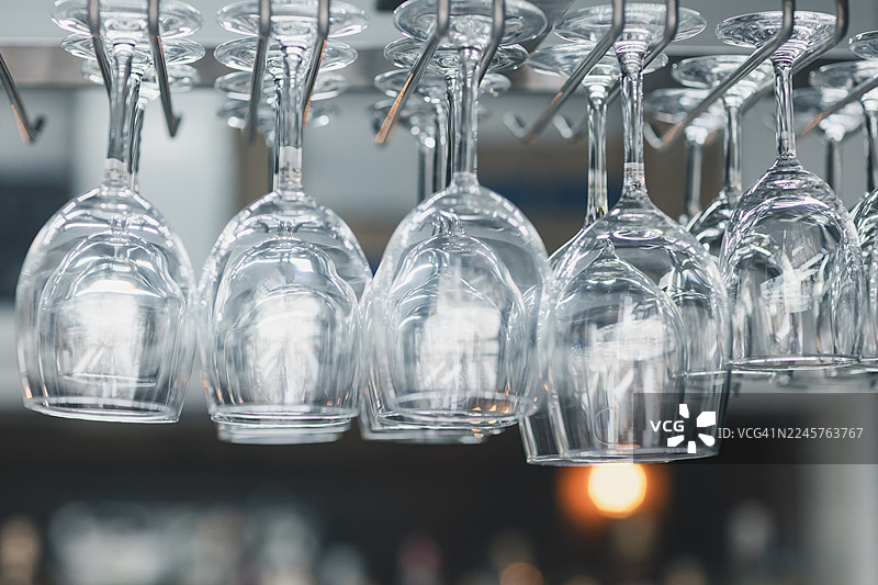 酒吧里整齐排列的干净酒杯倒挂着图片素材