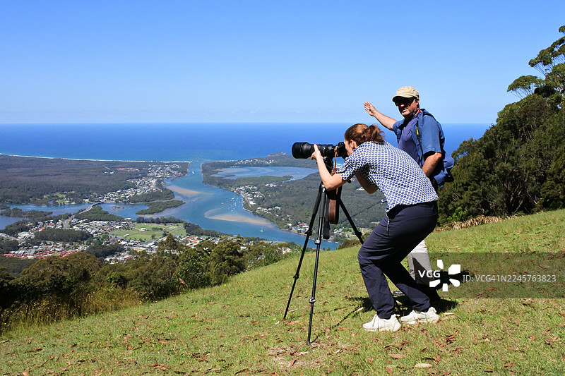 纪录片旅行摄影师正在教女学生如何拍摄澳大利亚新南威尔士州坎登天堂河的航拍风景照图片素材