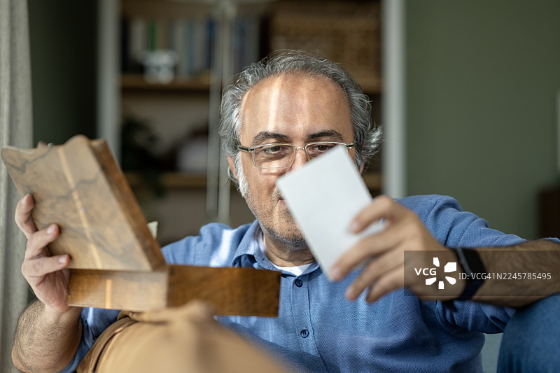 一名有阿尔茨海默病风险的男子正在看老照片图片素材